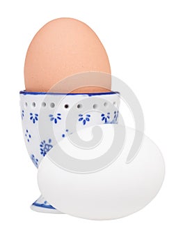 white egg and brown boiled egg in ceramic egg cup