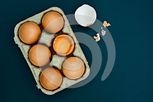 White egg and egg yolk in egg box on Light gray background, top view.