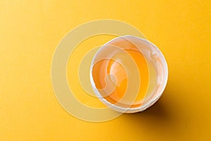 White egg and egg yolk on the yellow background. topview