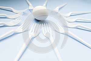 White egg and forks on a blue background