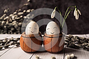 White eggs with a cute smile in a small wooden barrel with snowdrops and pussy willow branches with seals on a gray background 2