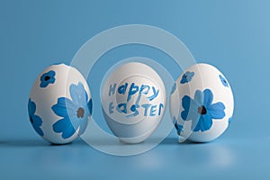 White eggs decorated with flowers on a blue background