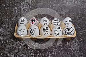 white eggs with drawn funny faces wearing medical masks at Easter holiday