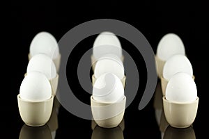 White eggs in egg-cups on black 4