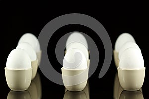 White eggs in egg-cups on black 5