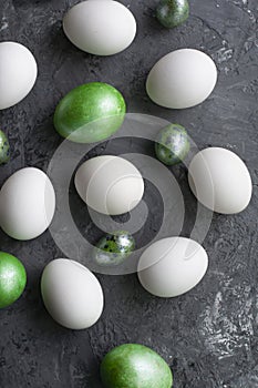 White eggs with green on a gray background, top view, flat lay, close up. Easter background.