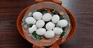 White eggs in a light brown wooden basket top view