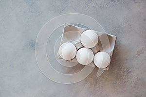 White eggs in a stand are on a gray concrete table. Cooking, food, ingredients