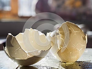 The white eggshell is split in two. The texture of the shell in the bright light, close -up, copy space. Background and texture of