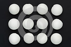 White eggshells are laid out in even rows on a black background. The concept of sameness, equality and equity. The concept of