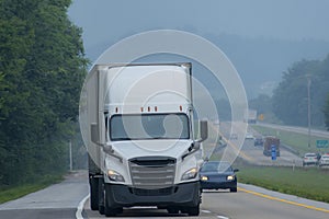 White Eighteen-wheeler drives through Tennessee Smoky Mountain Fog