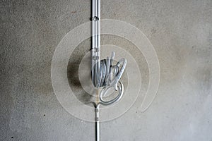 White electric cable attach on wall with aluminum cable clip. PVC insulated electrical wiring. With strap belt
