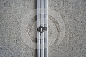 White electric cable attach on wall with aluminum cable clip. PVC insulated electrical wiring. With strap belt