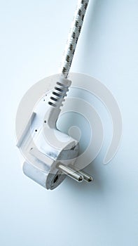 White electric cable from the iron on a light background.