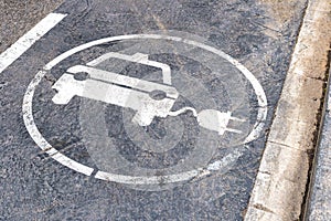 White electric car charging station sign on the road. Concept of ecological electric transport.