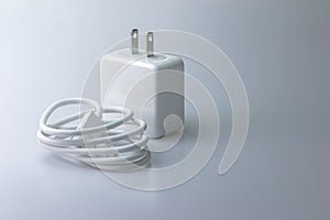 White electric charging with USB cable for phone on gray background