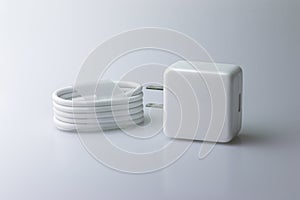 White electric charging with USB cable for phone on gray background