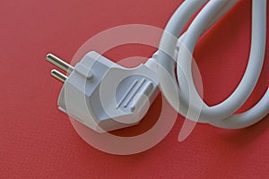 White electric euro plug on red background