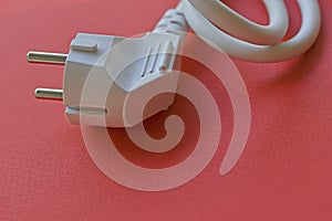 White electric euro plug on red background