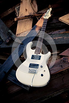 White electric guitar on a woodpile