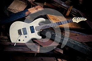 White electric guitar on a woodpile