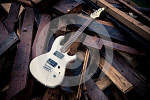 White electric guitar on a woodpile
