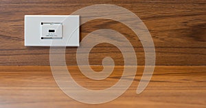 White electric plug socket and USB ports for charger on wooden wall for modern everyday facilities working computer and social