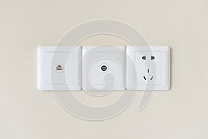 white electric plugs or outlet on wall, with tv and tel