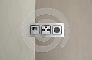 White electric socket and connector on the modern wall with pattern