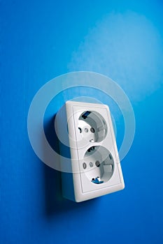 White electric socket on the wall.