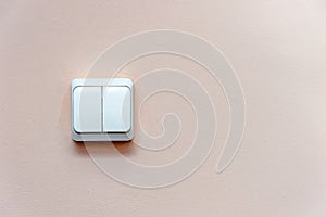 White electric switch on pink wall