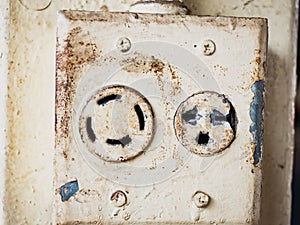 White electrical plug in the electric socket on a wall