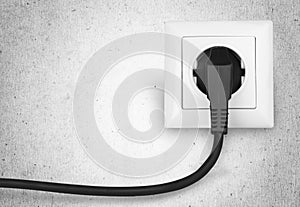White electrical plug in the electric socket on