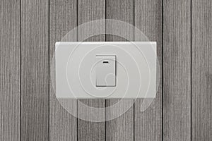 White electrical switch on wooden wall.