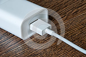 White electrical usb cord and charger plug in wall outlet