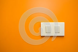 White electricity switch on orange wall background