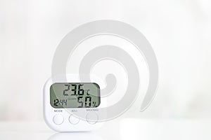 White electronic hygrometer on white table