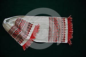 White embroidered towel on a green background.