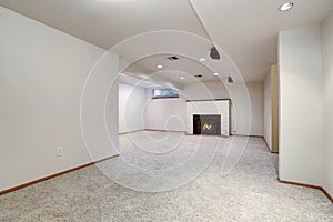 White empty basement room with fireplace