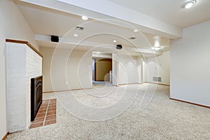 White empty basement room with fireplace