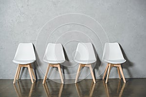 white empty chairs for job interview standing in line in hall