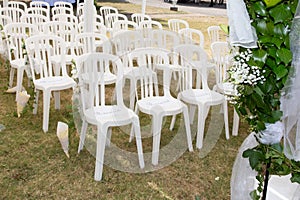 White empty chairs on lawn ready for secular wedding ceremony