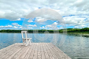 White empty deck chair at the lake dock.