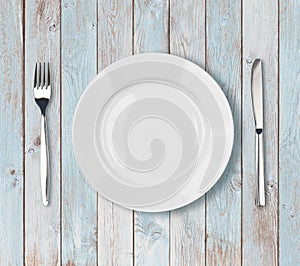 White empty dinner plate setting on blue wooden table