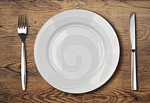White empty dinner plate setting on wooden table