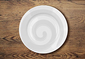 White empty dinner plate on wooden table surface