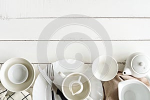 White empty dishes on wooden table with copy space
