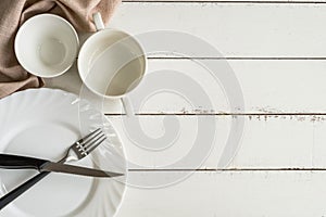 White empty dishes on wooden table with copy space