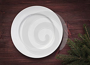 White empty plate on brown wooden surface