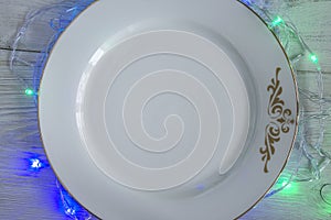 White empty plate with christmas illumination around